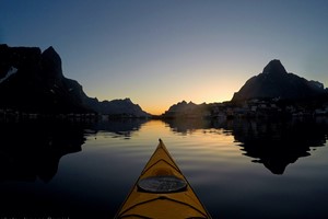 Hacer kayak disfrutando del sol de medianoche en Reine en las islas Lofoten - Noruega